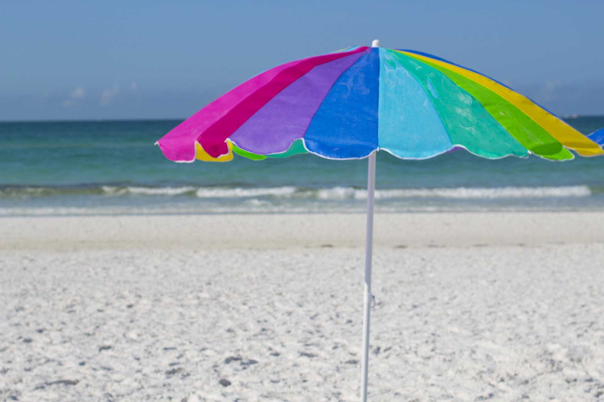 Ein farbenfroher Sonnenschirm am Strand