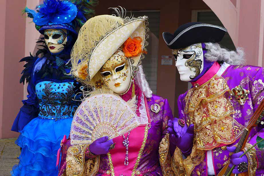 Menschen, die mit bunten venezianischen Masken posieren.