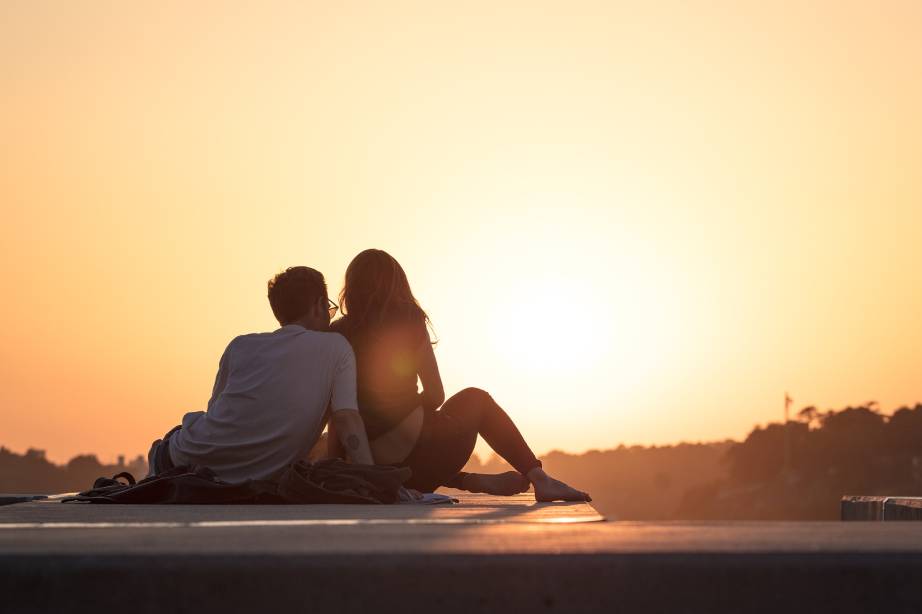 Verliebtes Paar sitzend beim Sonnenuntergang